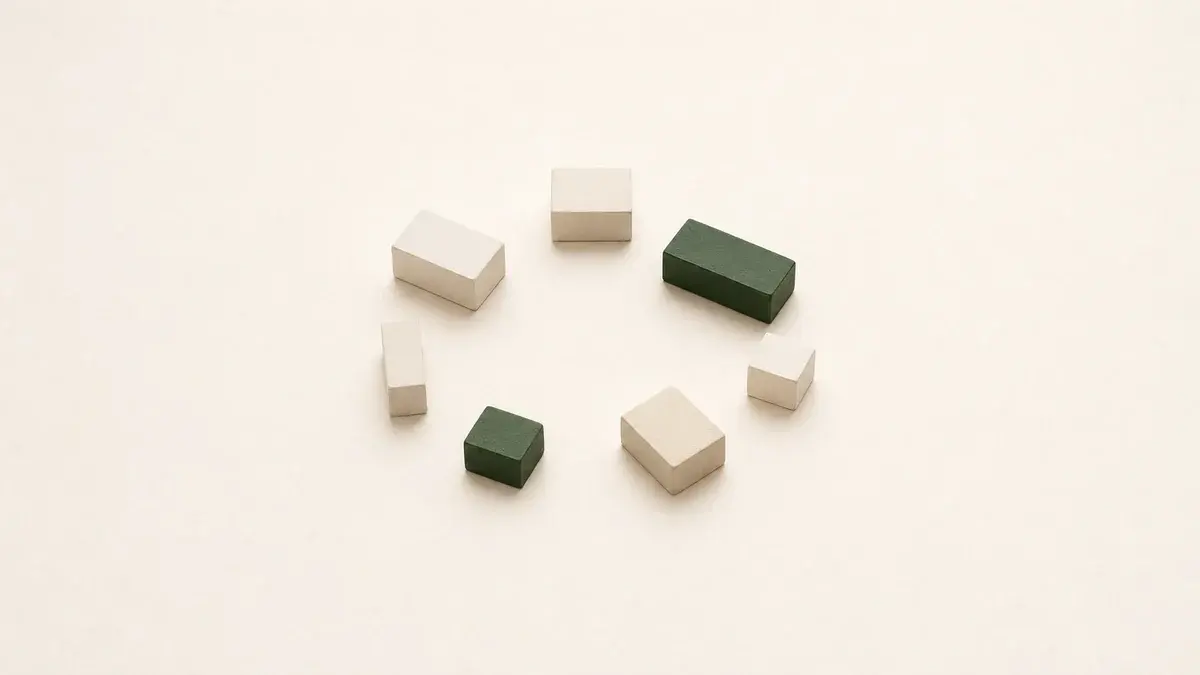 Small plaster and green blocks arranged in a loose circle on warm paper — a network forming